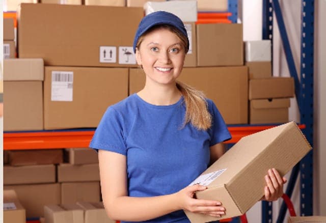 Arbeitsschutz in Lager und Logistik: Mitarbeiterin mit Paket im Versandlager